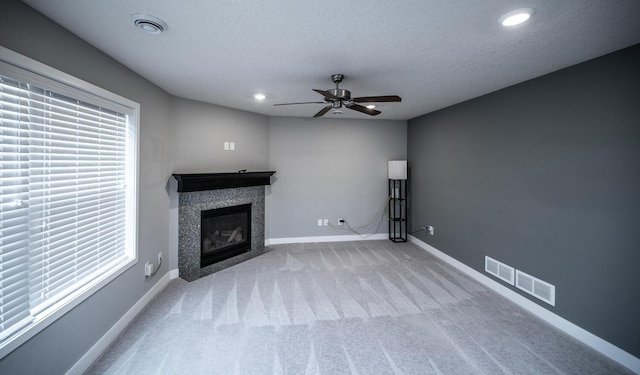 unfurnished living room featuring visible vents, carpet floors, baseboards, and a tile fireplace