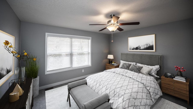 carpeted bedroom with visible vents, ceiling fan, a textured ceiling, and baseboards