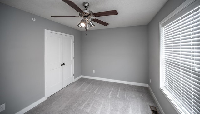 unfurnished bedroom with carpet flooring, baseboards, visible vents, and a textured ceiling