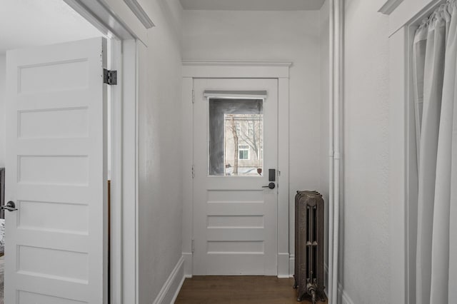 doorway to outside with dark wood-type flooring and radiator heating unit