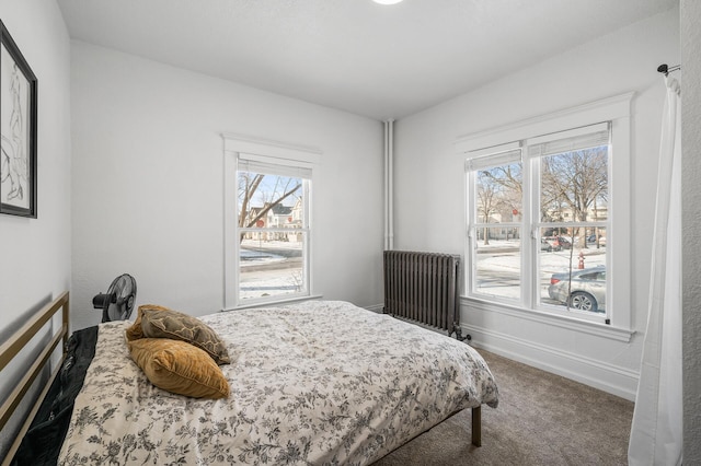 bedroom featuring multiple windows, carpet flooring, and radiator heating unit