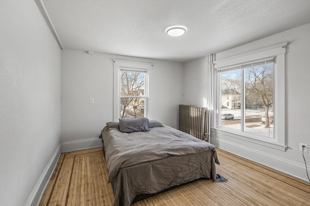 bedroom with hardwood / wood-style floors and a textured ceiling