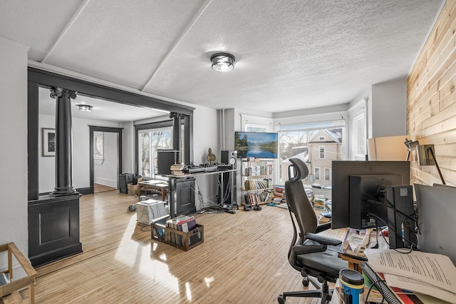 home office featuring a wealth of natural light, light hardwood / wood-style flooring, and a textured ceiling