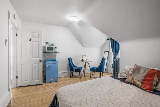 bedroom featuring vaulted ceiling and wood-type flooring