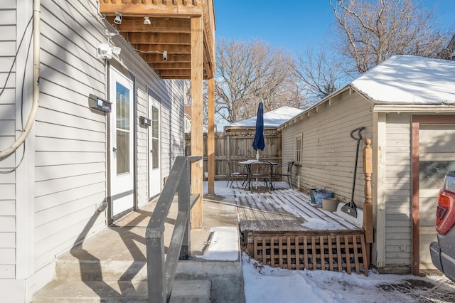 snow covered patio featuring a deck