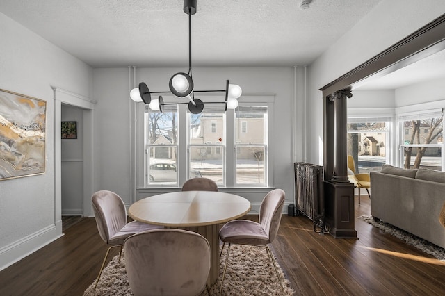 dining area with radiator heating unit, dark hardwood / wood-style floors, and a textured ceiling