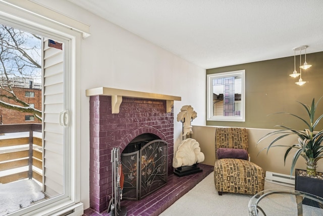 sitting room featuring a baseboard heating unit, a brick fireplace, and carpet