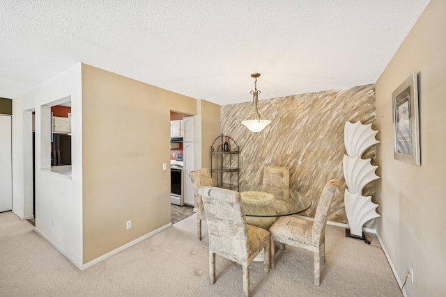 dining area with a textured ceiling, an accent wall, carpet flooring, and baseboards