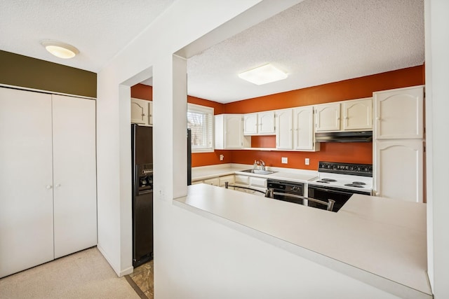 kitchen featuring a sink, under cabinet range hood, a textured ceiling, and electric stove