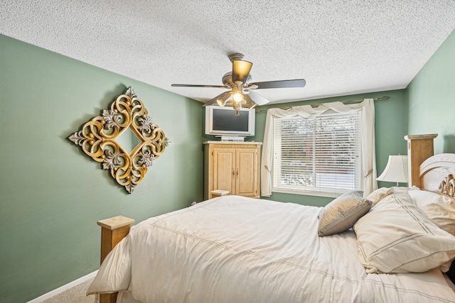 carpeted bedroom featuring a textured ceiling, baseboards, and a ceiling fan