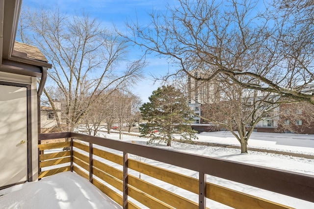 view of snow covered back of property