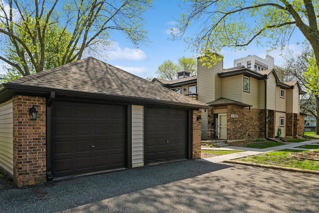 340 Ford Rd Unit 5, Saint Louis Park, MN 55426 - view of front of property with brick siding, a shingled roof, an outbuilding, a garage, and a chimney