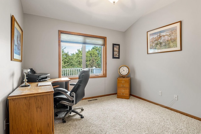 carpeted office space with vaulted ceiling