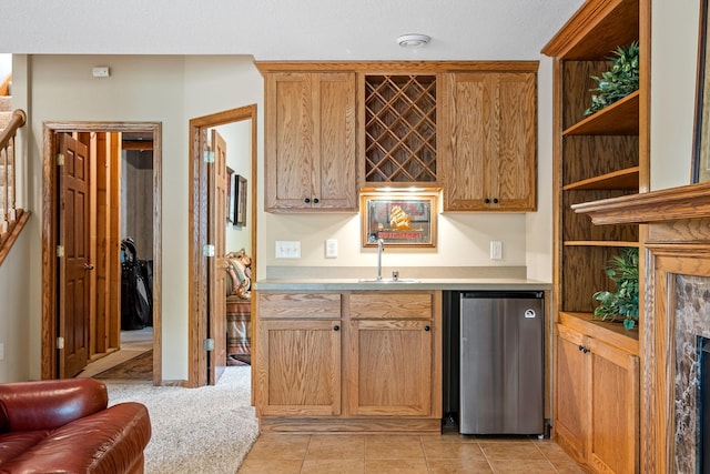 kitchen with sink, light colored carpet, and stainless steel refrigerator