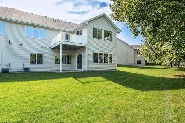 back of house featuring a balcony, a lawn, and central air condition unit