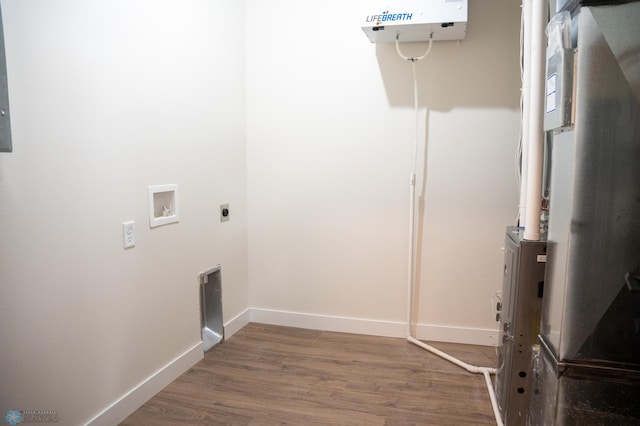 clothes washing area featuring heating unit, washer hookup, wood-type flooring, and electric dryer hookup