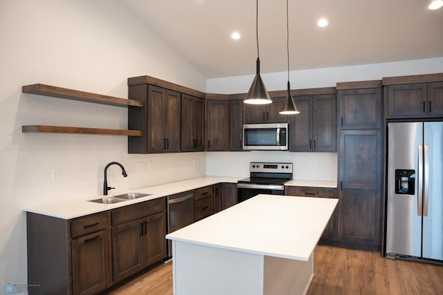 kitchen with sink, decorative light fixtures, vaulted ceiling, dark brown cabinets, and appliances with stainless steel finishes