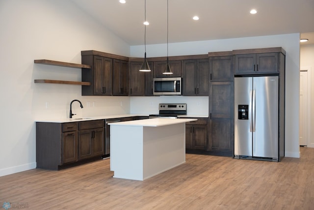 kitchen featuring appliances with stainless steel finishes, sink, hanging light fixtures, dark brown cabinets, and light hardwood / wood-style flooring