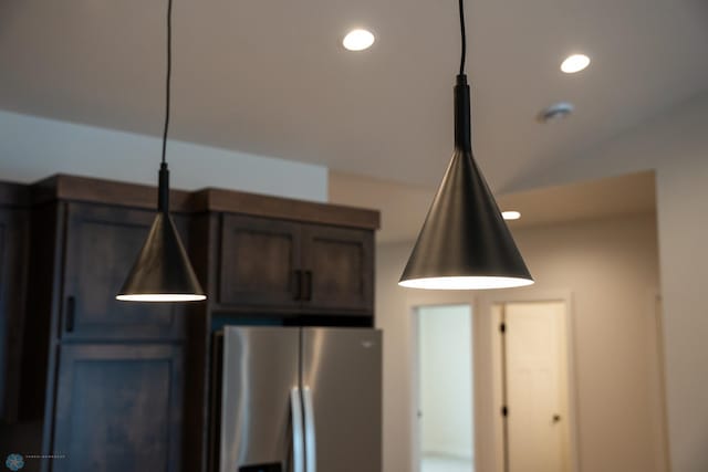 room details featuring stainless steel fridge with ice dispenser and dark brown cabinets