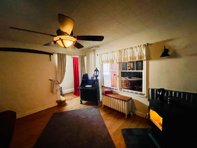 misc room featuring radiator, hardwood / wood-style floors, and ceiling fan