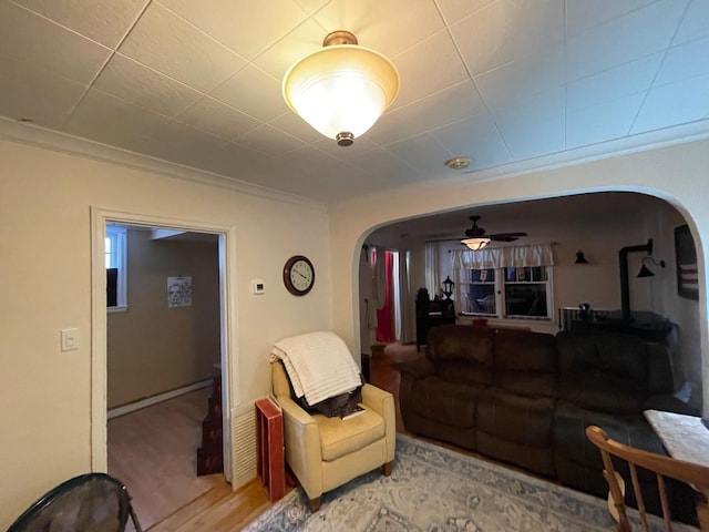 living room featuring ornamental molding, ceiling fan, and light hardwood / wood-style floors