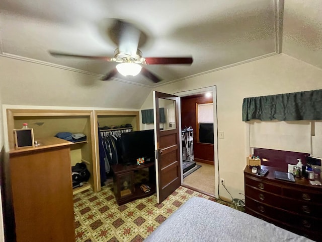 bedroom with ceiling fan, lofted ceiling, and a closet