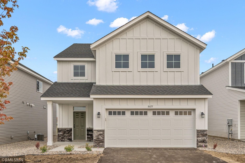 view of front of home with a shingled roof, aphalt driveway, and board and batten siding