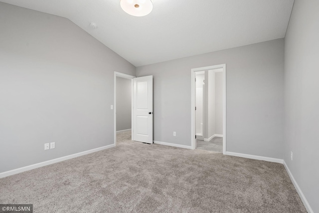 unfurnished bedroom with light colored carpet and lofted ceiling