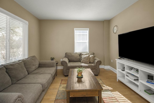 living area with light wood-style flooring and baseboards