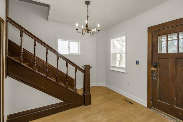 entrance foyer with light wood-type flooring, stairway, plenty of natural light, and visible vents