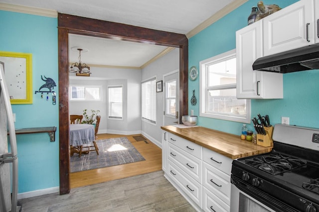 kitchen featuring light wood-style floors, appliances with stainless steel finishes, wooden counters, and ornamental molding