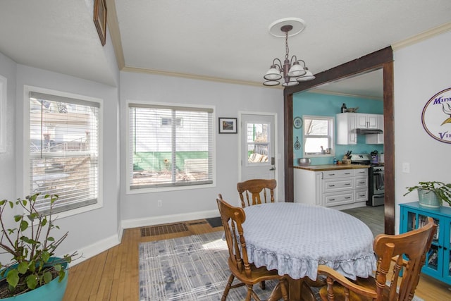 dining area featuring an inviting chandelier, baseboards, ornamental molding, and wood finished floors