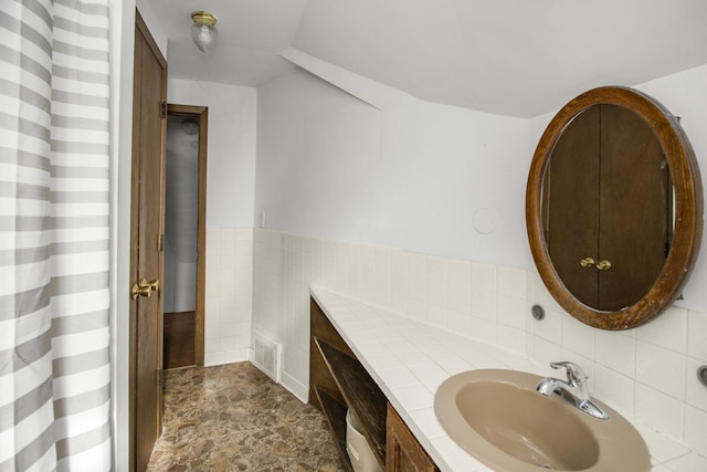 full bath with stone finish flooring, visible vents, and vanity