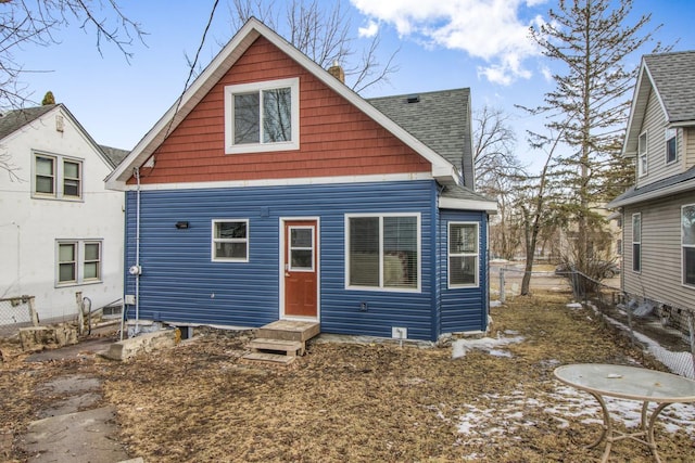 back of property featuring entry steps and a shingled roof