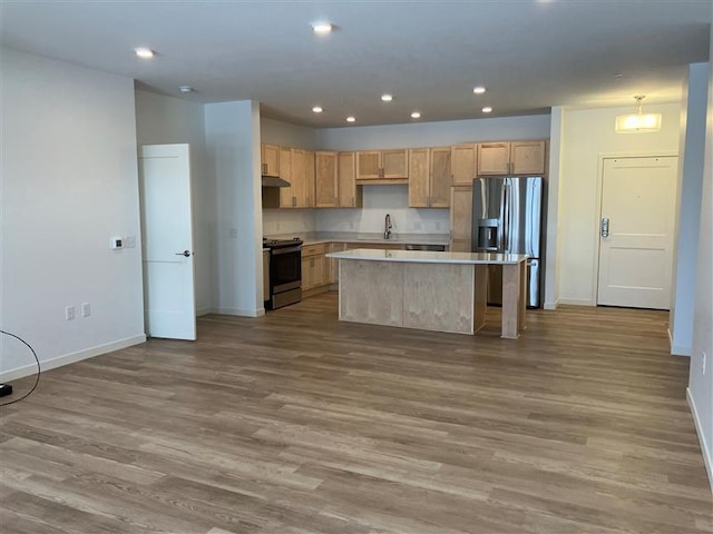 kitchen featuring sink, light hardwood / wood-style flooring, light brown cabinets, a kitchen island, and stainless steel appliances