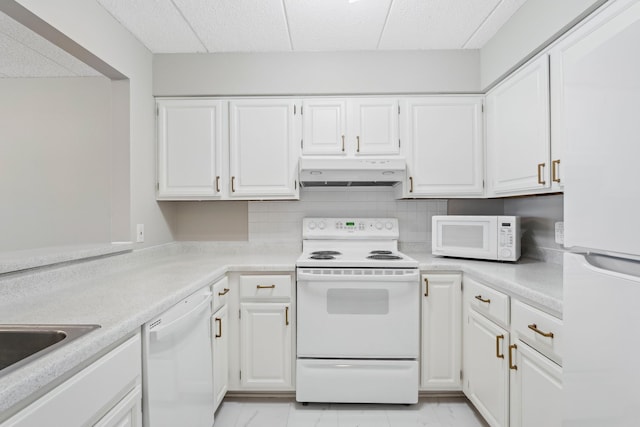 kitchen with under cabinet range hood, white appliances, white cabinets, marble finish floor, and light countertops