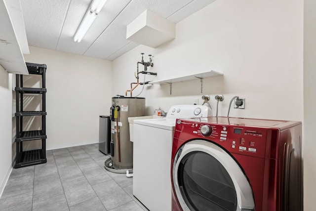 laundry area featuring light tile patterned floors, water heater, a textured ceiling, washer and dryer, and laundry area