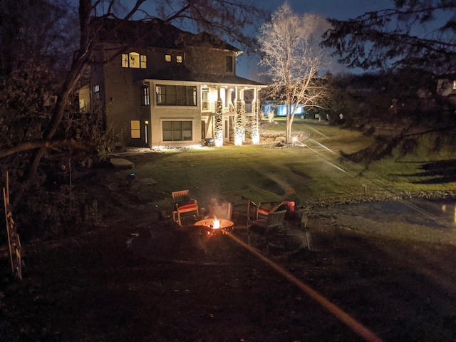 back house at twilight with an outdoor fire pit