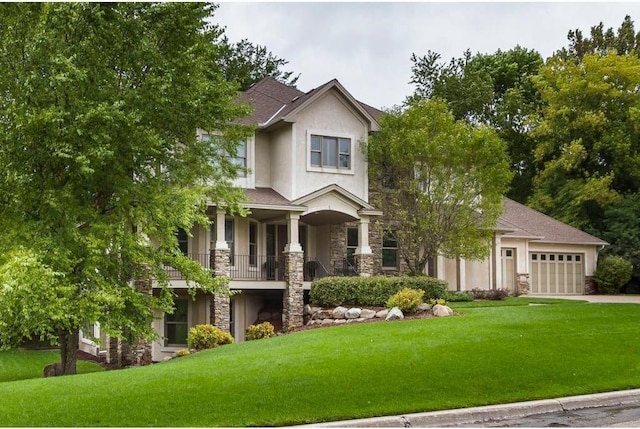 view of front of house with a garage, a front yard, and a balcony