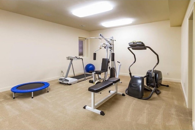 workout room featuring light carpet