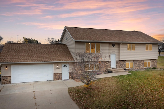 view of front of property featuring a garage and a lawn