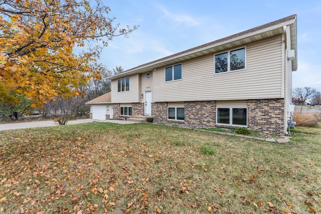 rear view of property with a yard and a garage