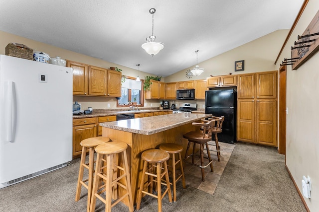 kitchen with pendant lighting, sink, a breakfast bar area, black appliances, and a kitchen island