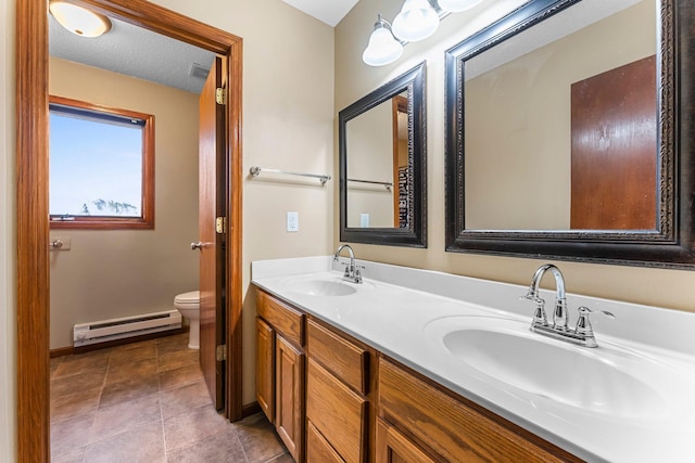 bathroom with vanity, a baseboard heating unit, toilet, tile patterned floors, and a textured ceiling