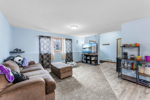 living room featuring baseboard heating, hardwood / wood-style floors, and a textured ceiling