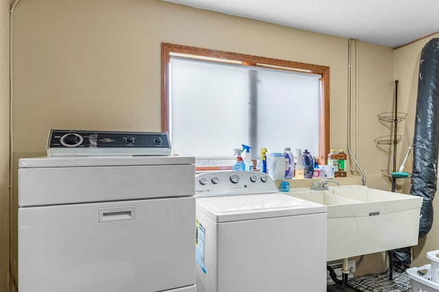 clothes washing area with sink and washer and dryer