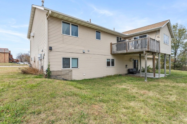 back of property featuring a wooden deck, a patio area, and a lawn