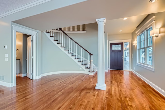 foyer featuring wood-type flooring and ornate columns