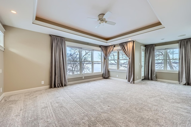 carpeted empty room featuring ceiling fan and a tray ceiling