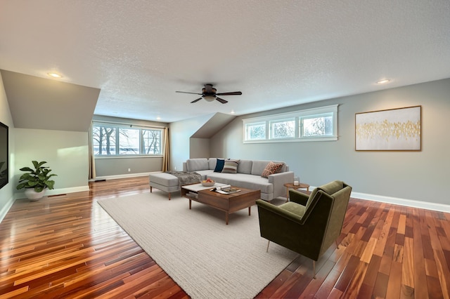 living room with ceiling fan, dark hardwood / wood-style floors, and a textured ceiling